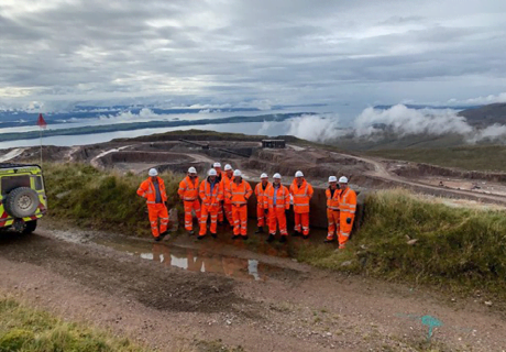 Group of workers in PPE with a quarry in the background
