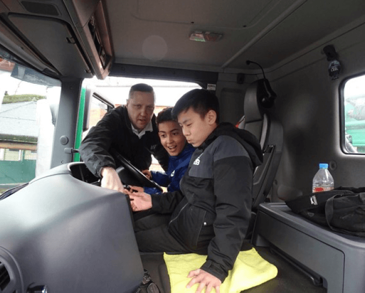 Two kids sat in a lorry