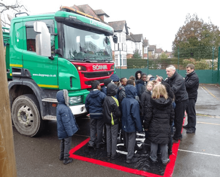 Group of kids being spoken to about a lorry
