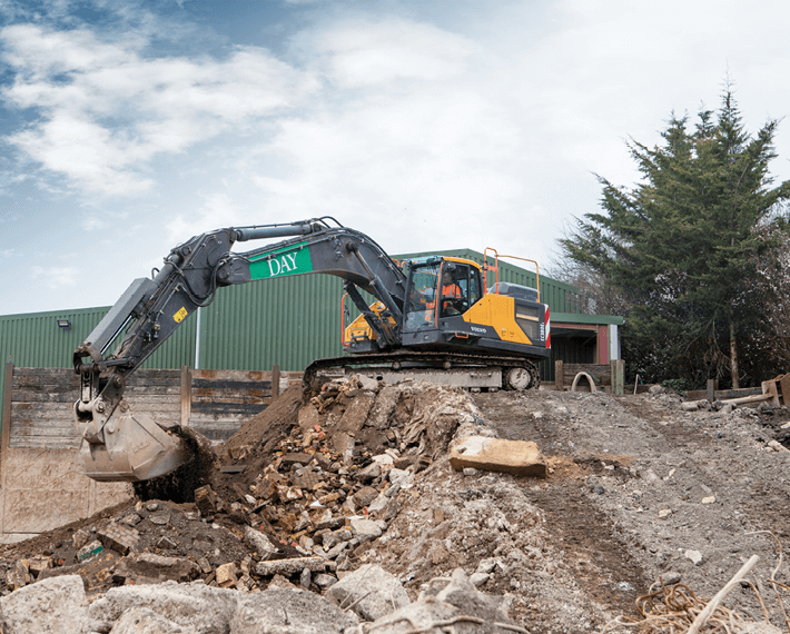 Yellow Day Aggregates excavator on top of a pile of rubble.