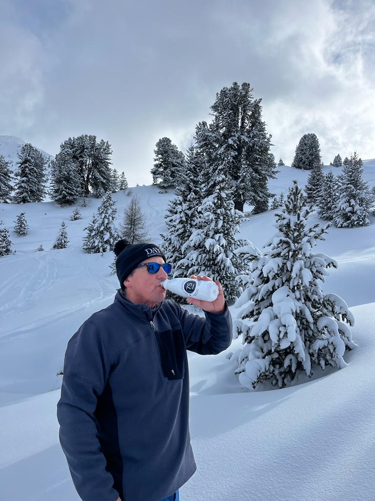 A man drinking water on the snowy mountains