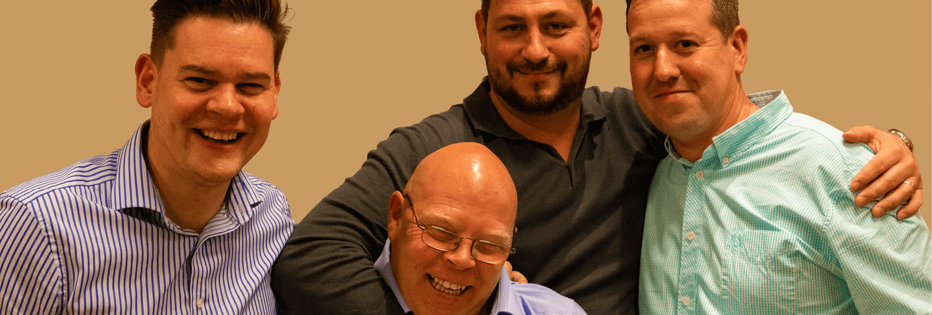 four men at a conference smiling
