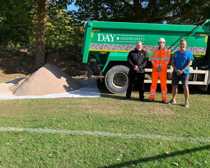 Day Aggregates lorry parked with workers standing in front and a pile of material