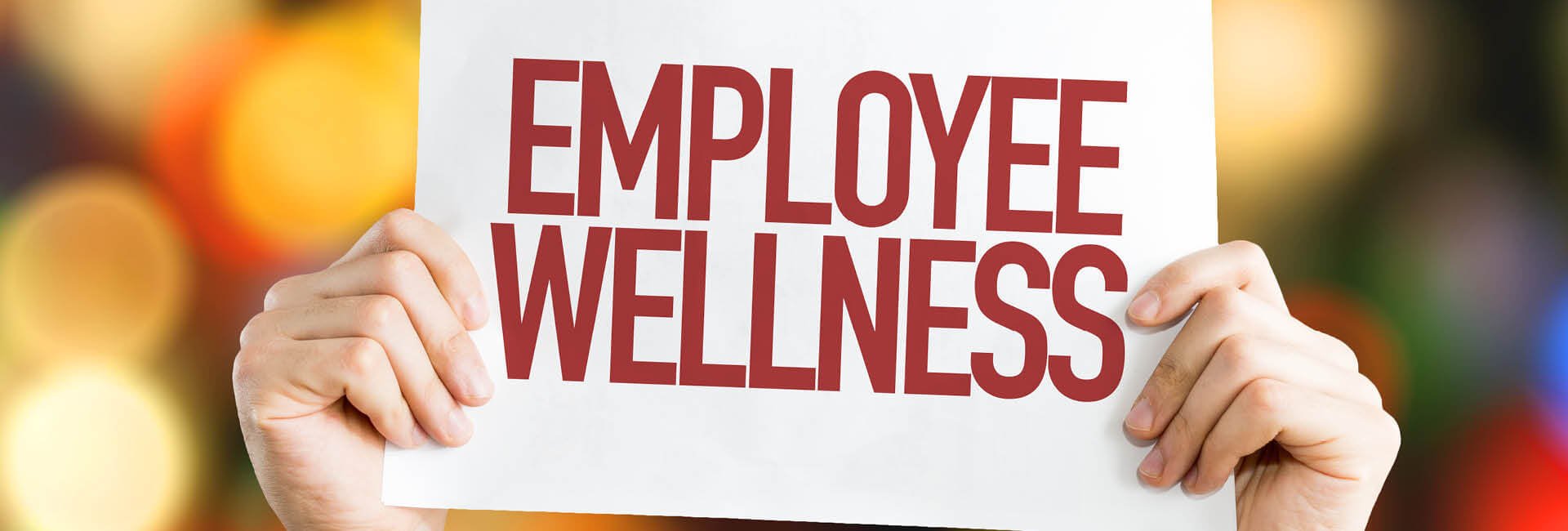 A sign saying employee wellness being held up