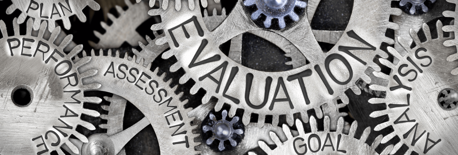 Cogs spinning with the words, evaluation, goals, analysis, assessment, plan and performance engraved in the cogs